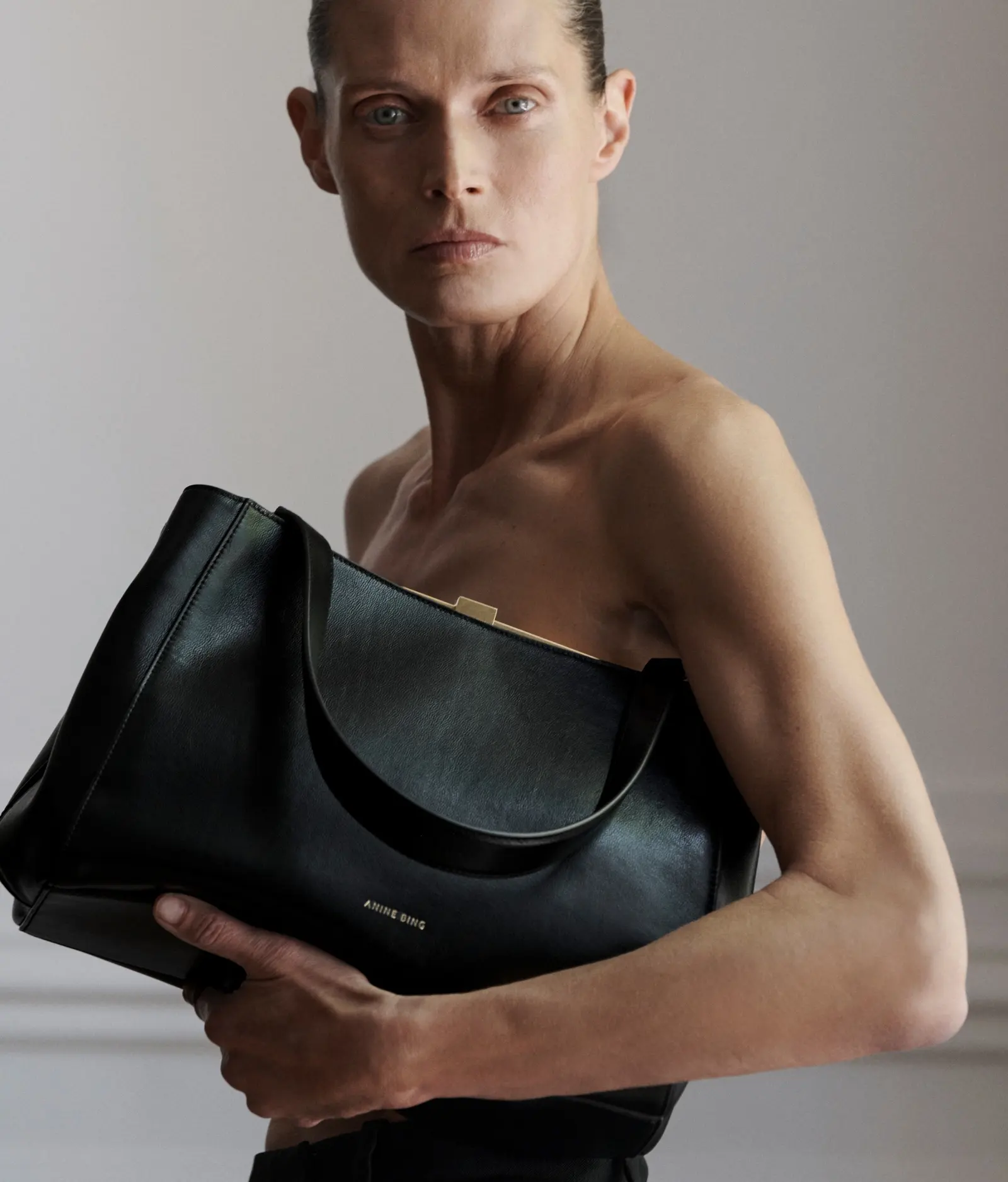 A model holding a black leather Anine Bing bag