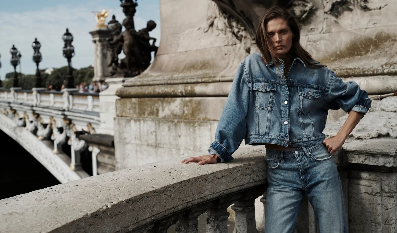 An Anine Bing denim jacket on a stone bridge