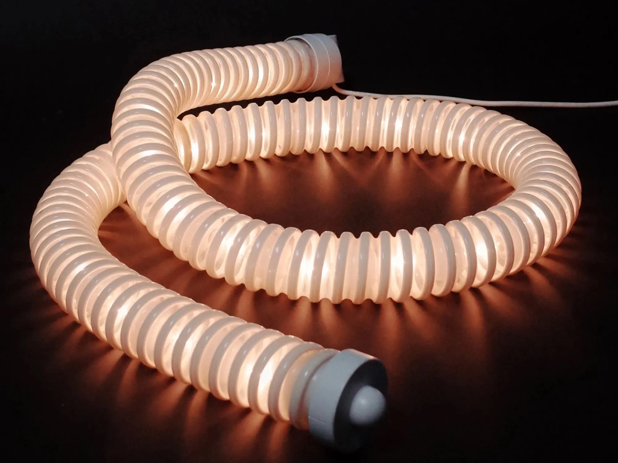 A glowing ribbed tube lamp at Formas
