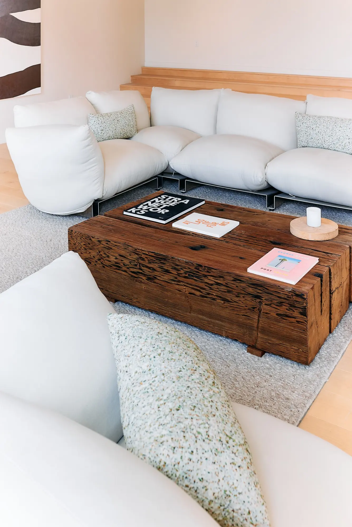 A white sofa and carved wooden coffee table in the Greycroft office at Signal