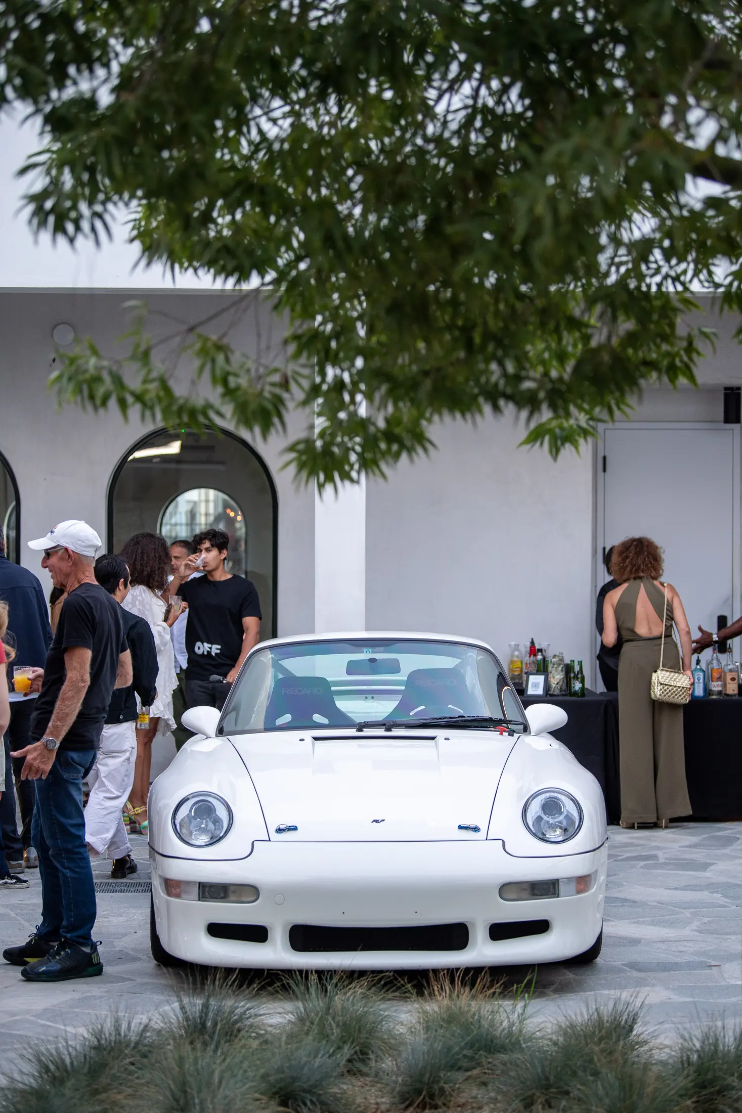Guests around a white Porsche in the courtyard at Signal