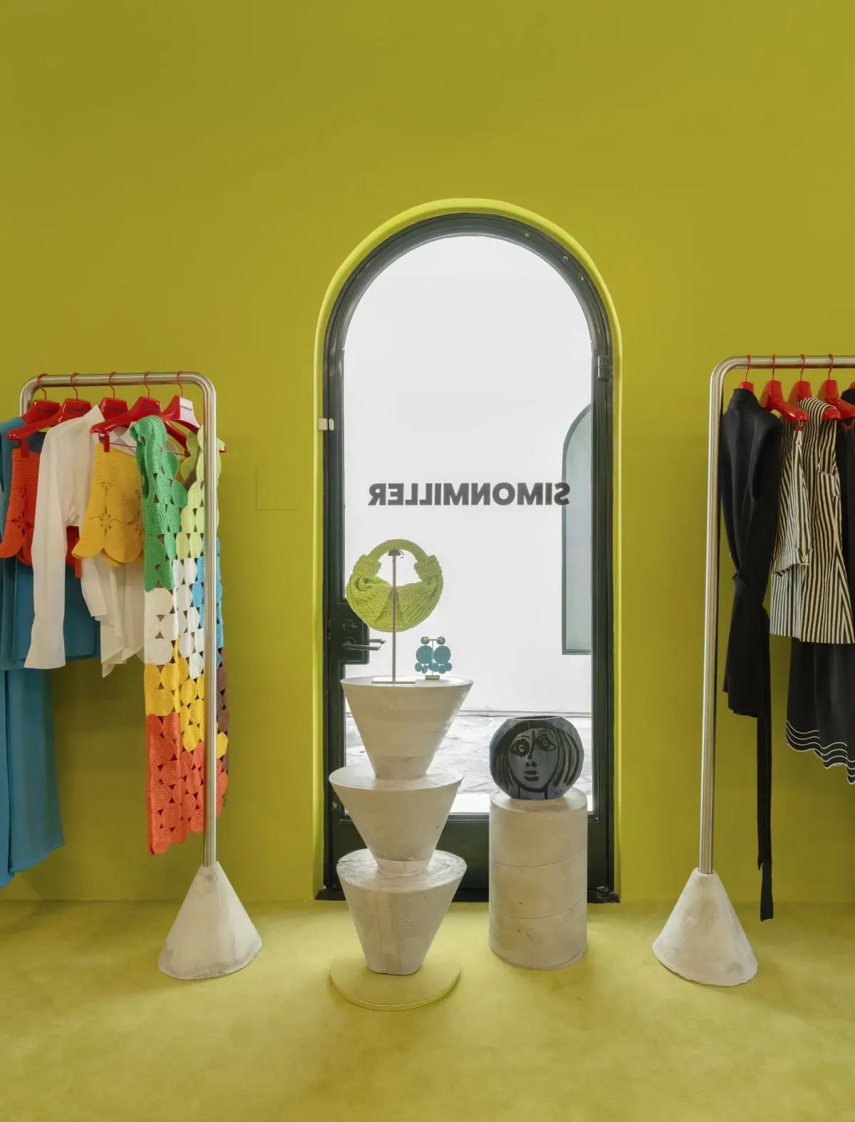Clothing rails and an arched mirror in the Simon Miller store at Signal